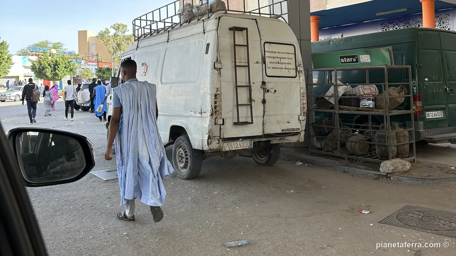 Una strada del centro di Nouakchott, con un uomo in daraa e un furgone