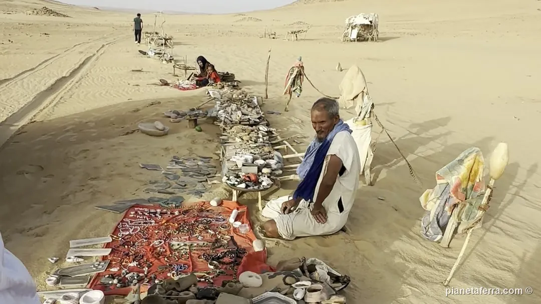 Bancarelle di souvenir stese sulla sabbia dentro l'Occhio del Sahara