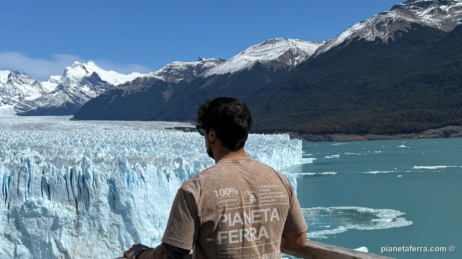 Luca di spalle su un balcone delle passerelle davanti alla parete del Perito Moreno e ai blocchi di ghiaccio nel lago