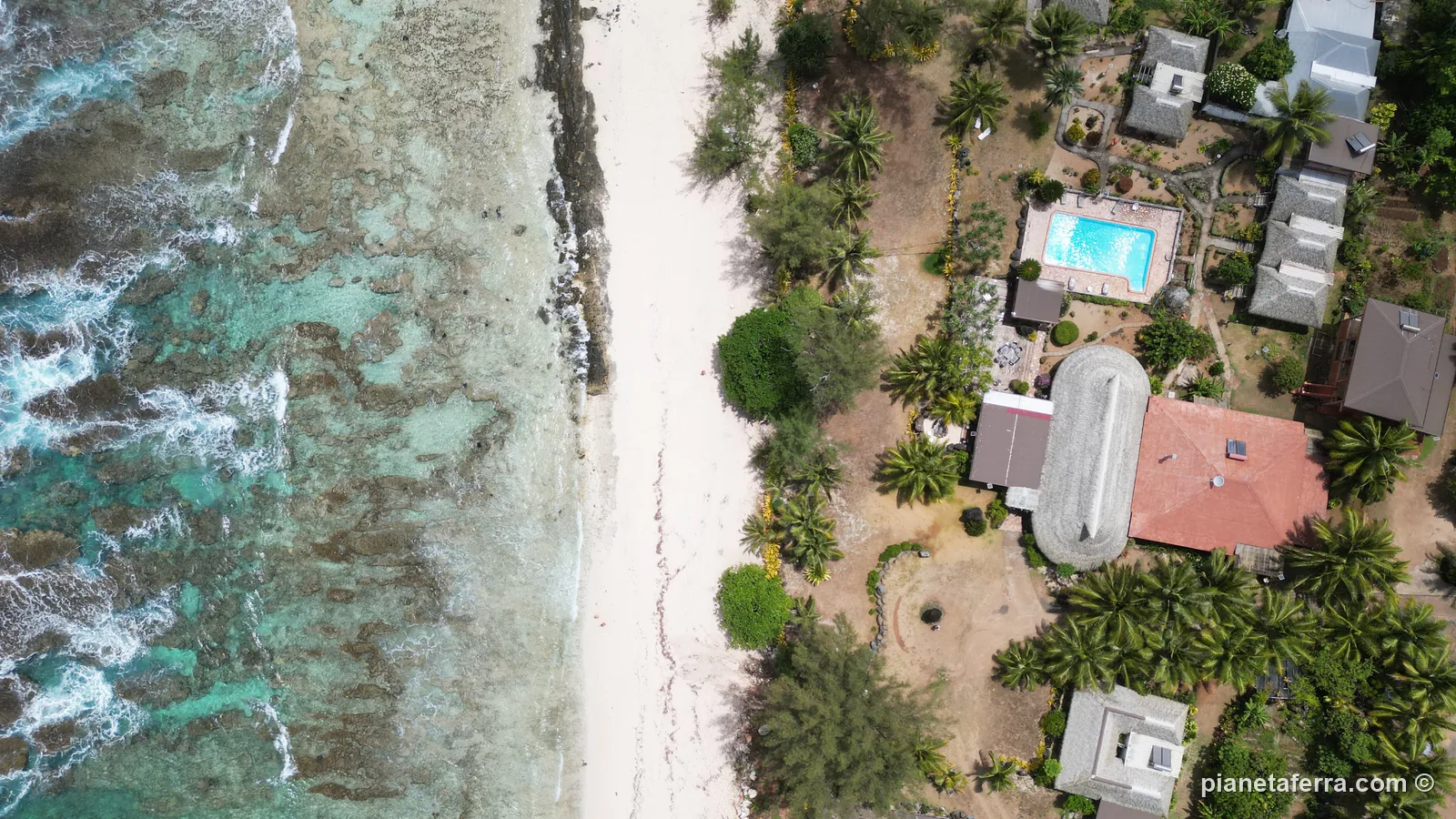La costa di Rurutu, nelle Isole Australi, vista dal drone: la spiaggia, la barriera e le case tra le palme