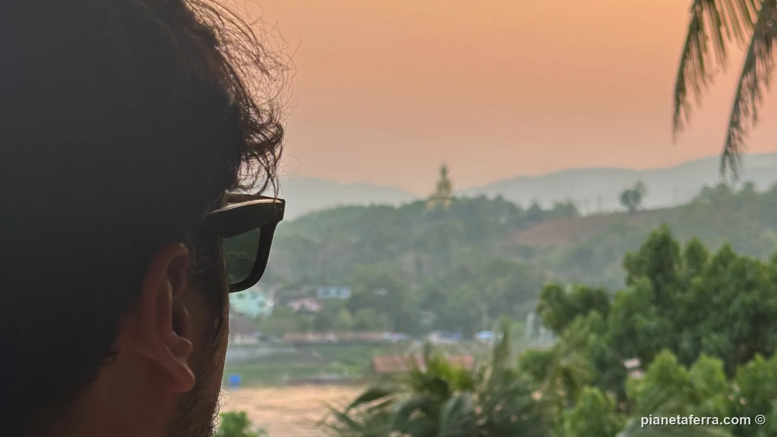 Luca guarda il Mekong al tramonto a Huay Xai ad aprile, con le colline velate dal fumo dei roghi agricoli