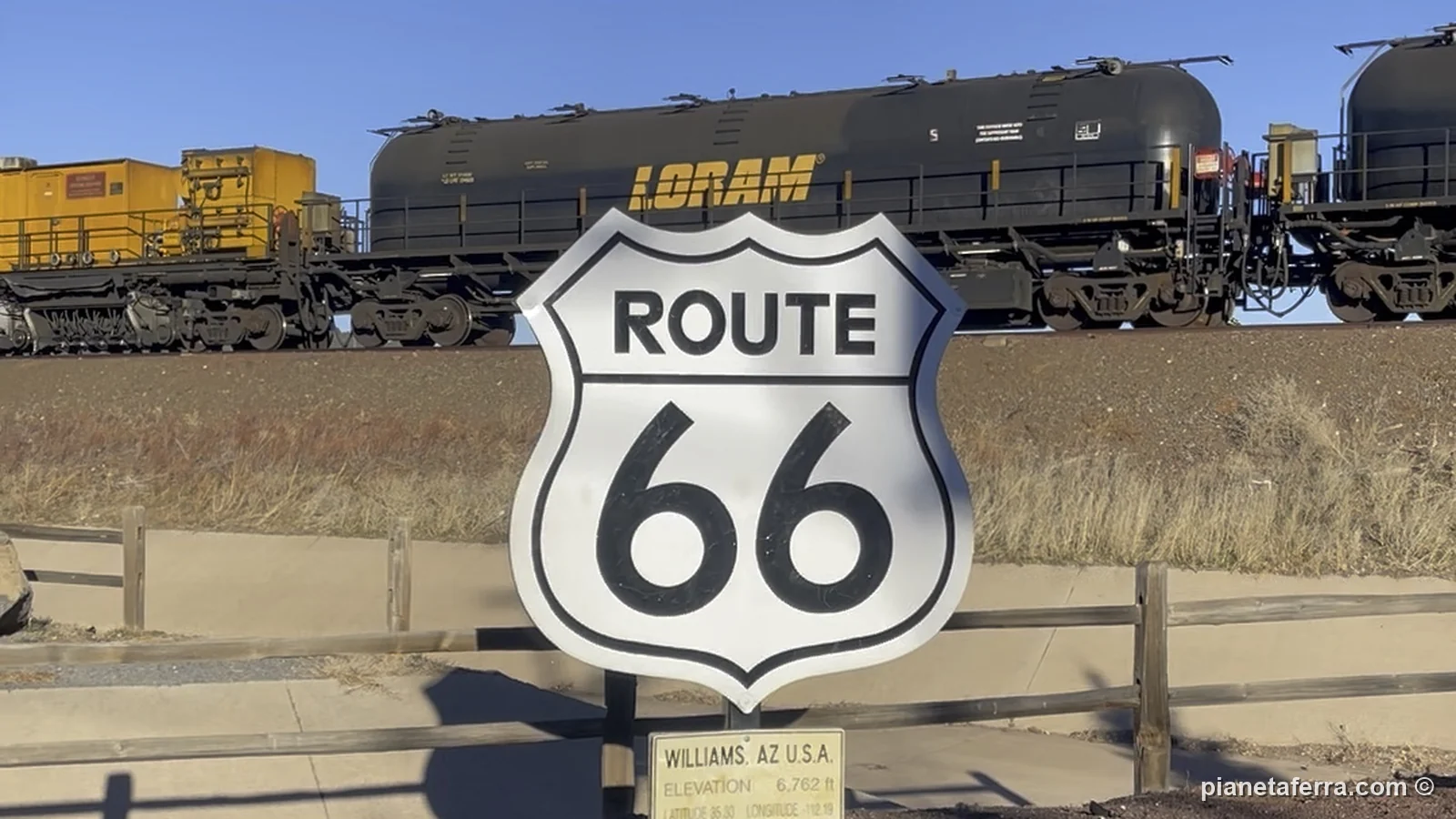 Il cartello della Route 66 a Williams con un treno merci sullo sfondo, a febbraio 2022