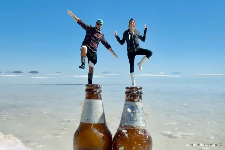 Gioco prospettico sul Salar de Uyuni con due bottiglie di cerveza Uyuni