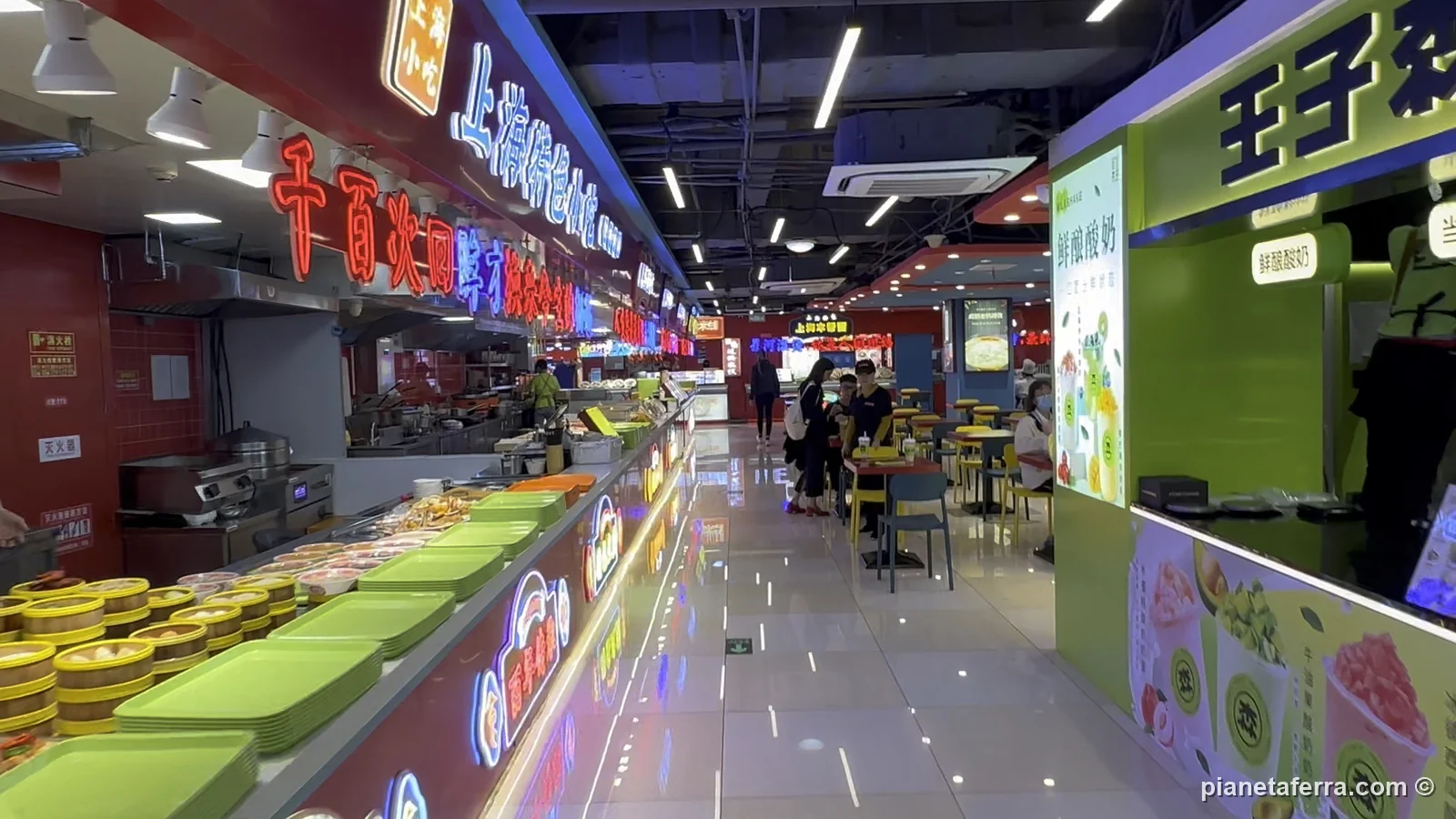 Un food court con i banchi illuminati vicino a Nanjing Road, a Shanghai, nel 2024