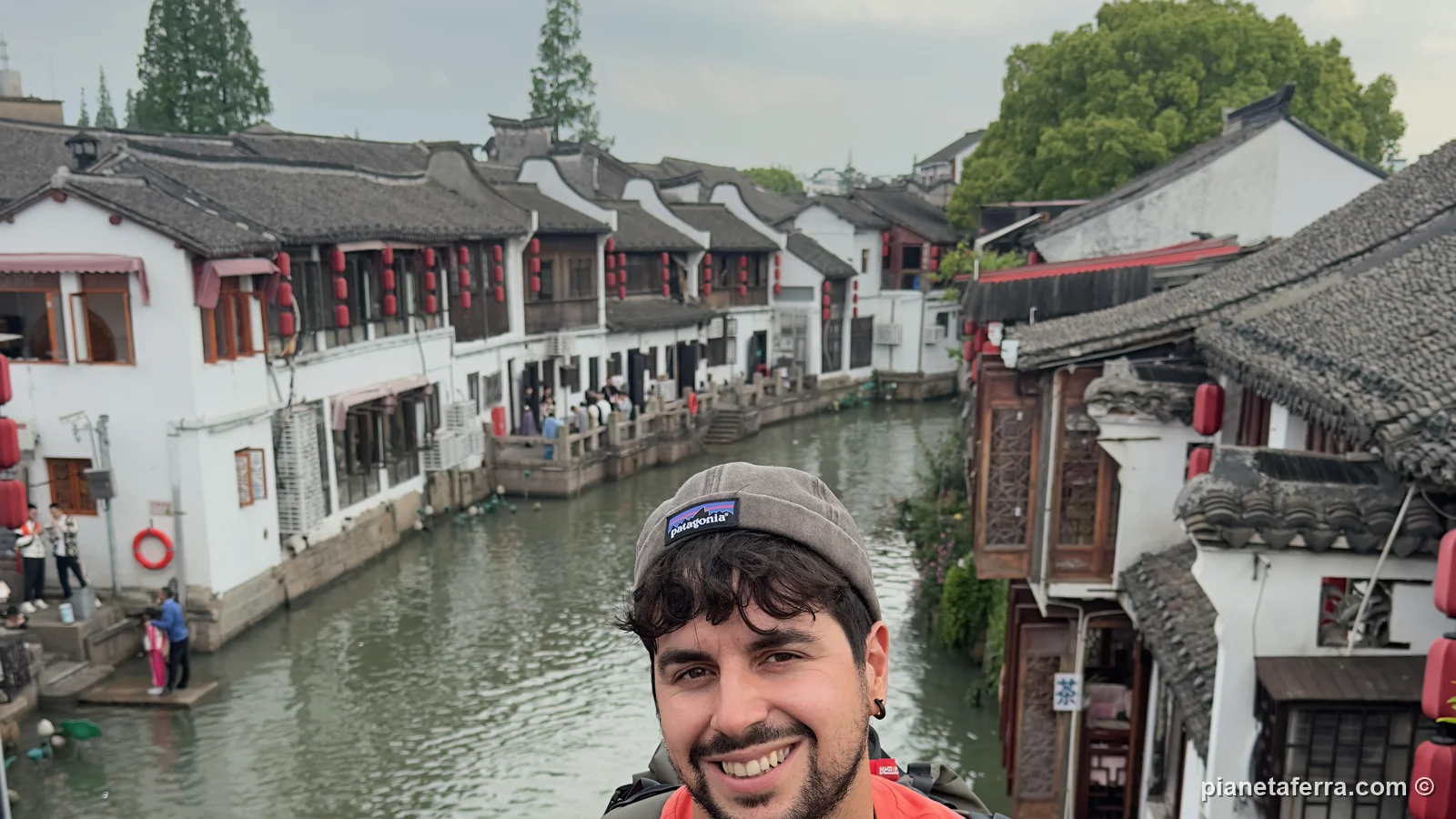 Luca sul ponte sopra un canale di Zhujiajiao, la città sull'acqua vicino a Shanghai, nel 2024