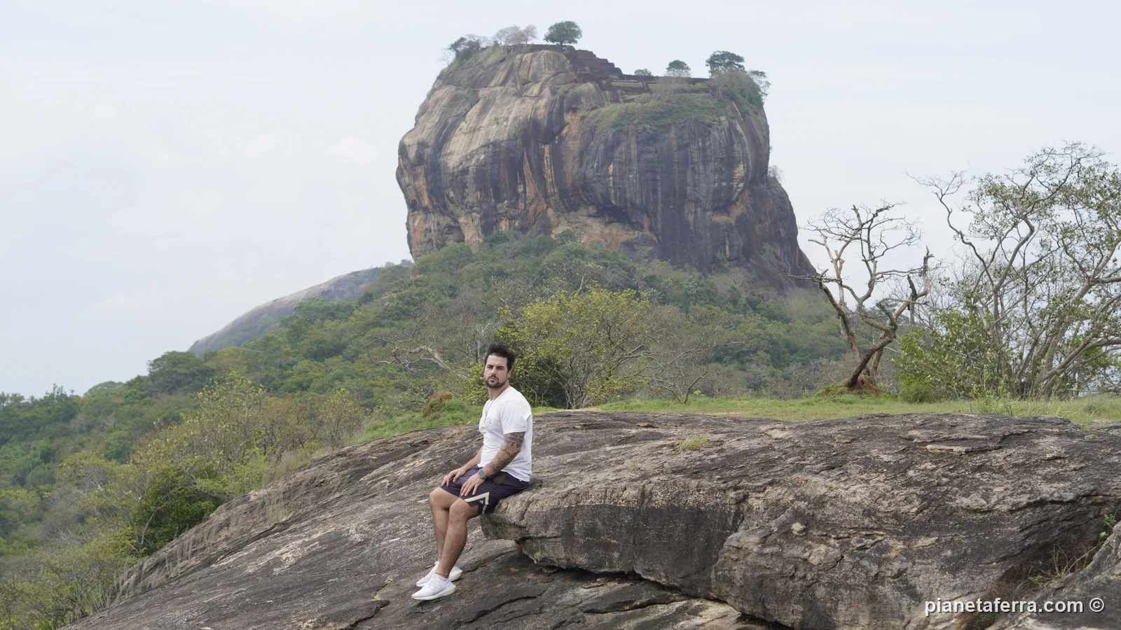 Luca Ferraina seduto sul viewpoint gratuito con la Lion Rock di Sigiriya alle spalle, a maggio 2024
