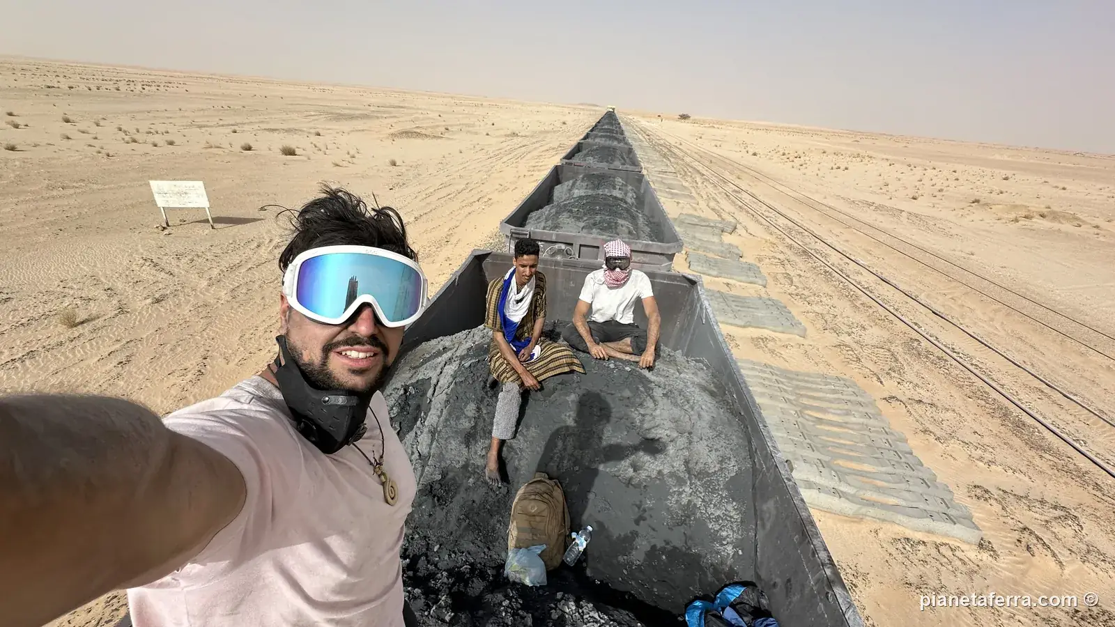 Selfie di Luca con gli occhiali sul vagone del minerale a metà mattina, con Matteo e un altro passeggero seduti dietro
