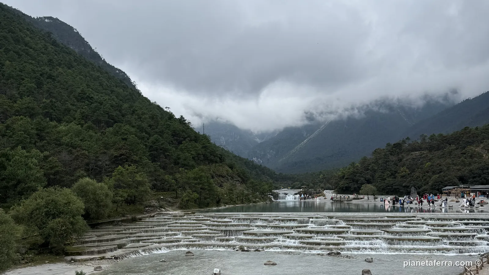 La valle del fiume Baishui con le nuvole basse sulla Montagna del Drago di Giada