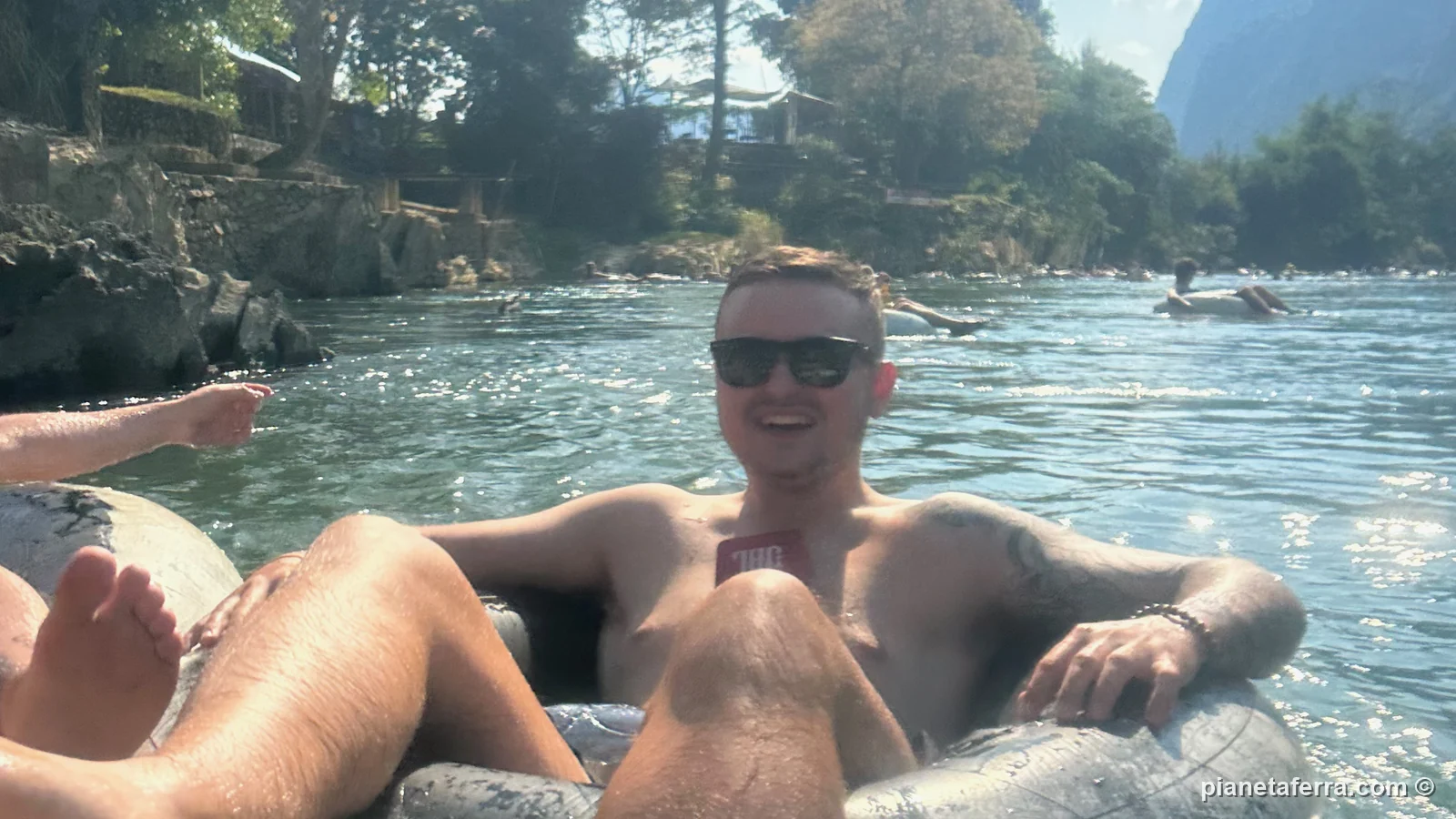 Un amico di Luca seduto sulla camera d'aria durante il tubing sul fiume Nam Song a Vang Vieng