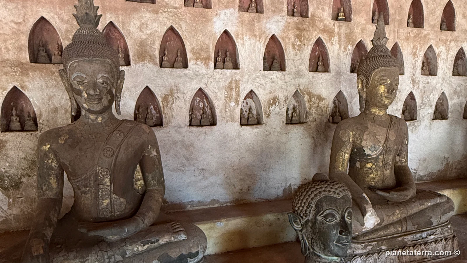 Le statue di Buddha e le nicchie con i piccoli Buddha nel chiostro di Wat Si Saket a Vientiane