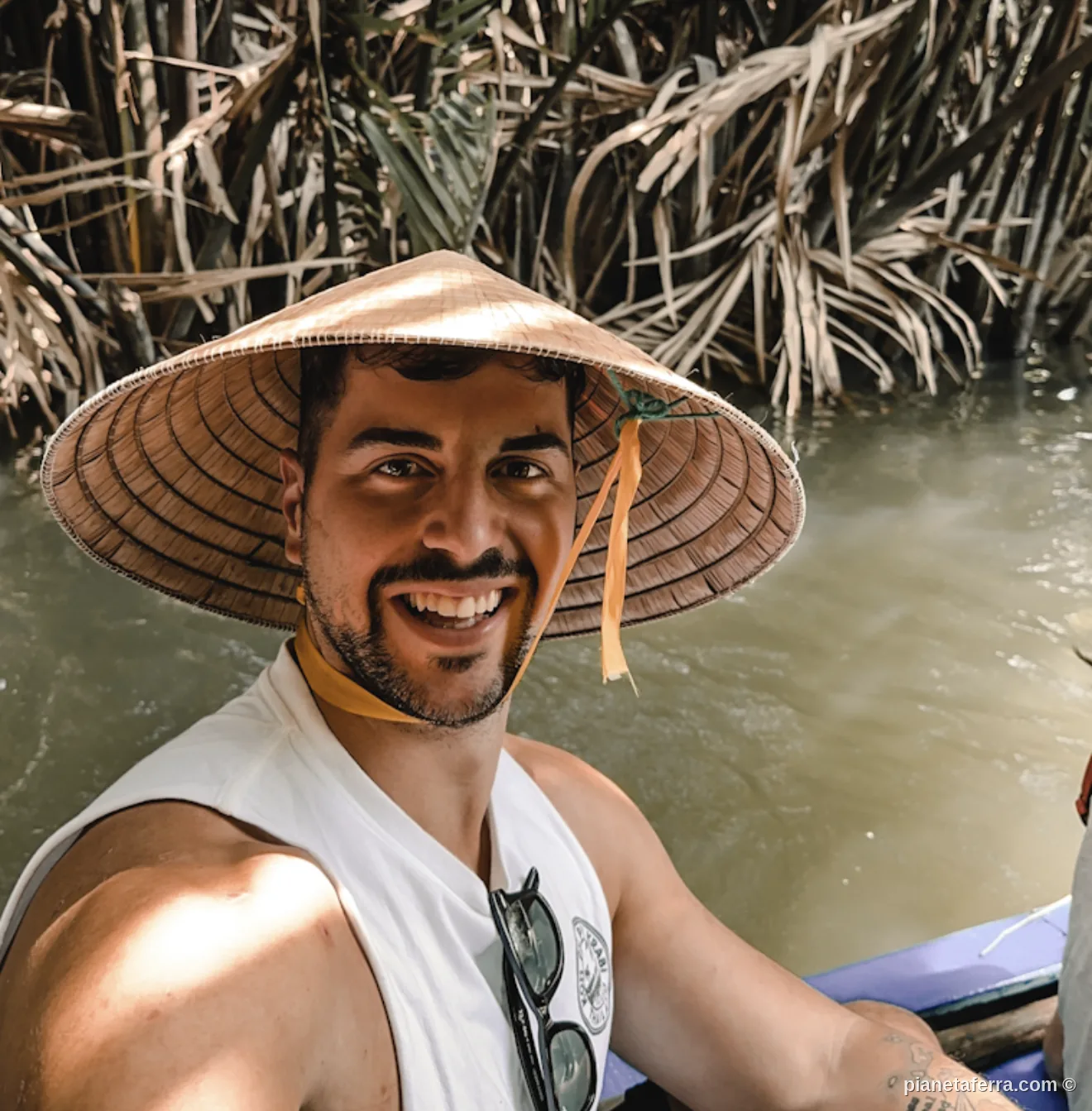 In barca con cappello conico nei canali del Delta del Mekong, sud Vietnam