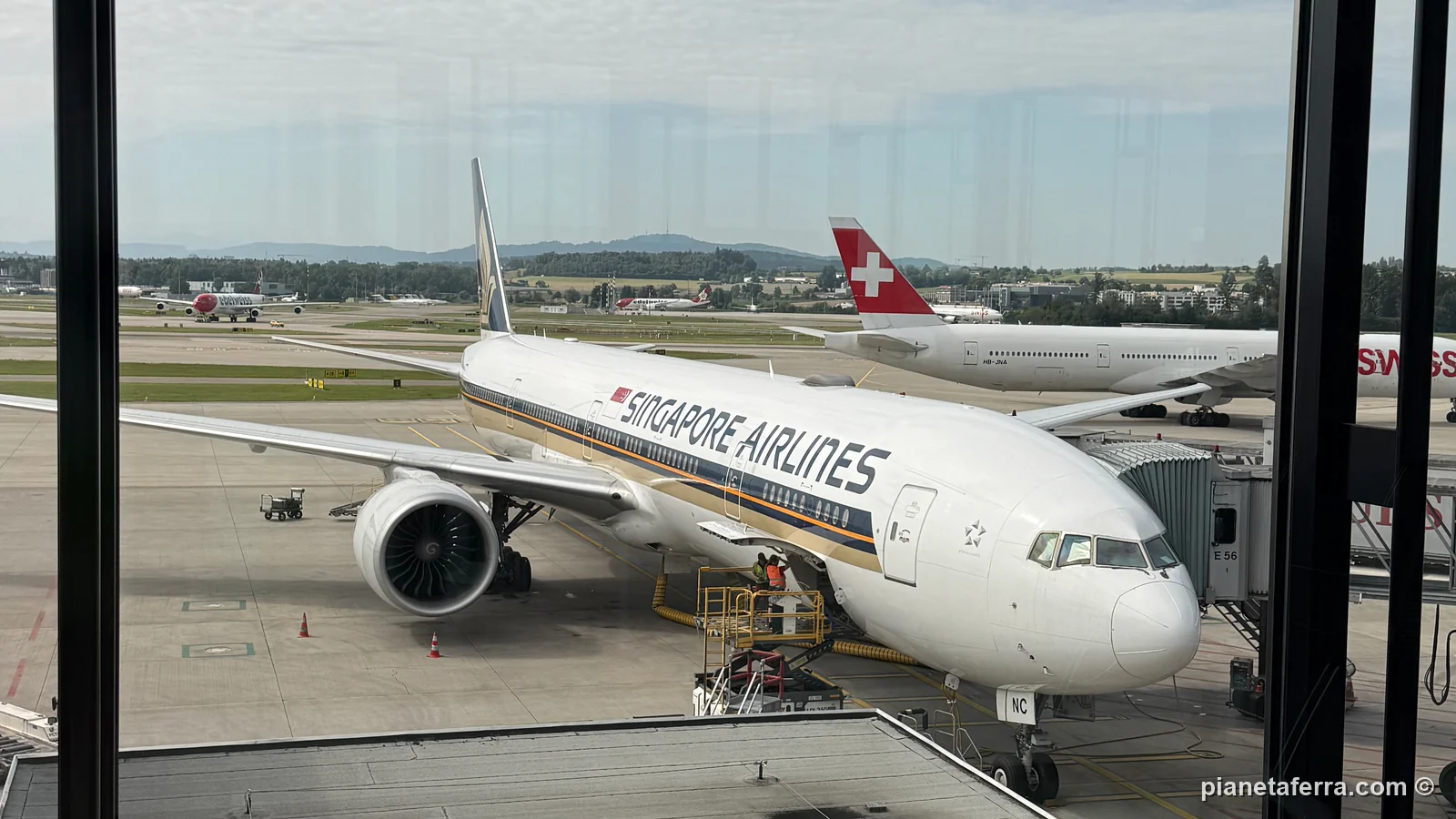 Un aereo di linea fermo al gate dell'aeroporto di Zurigo, visto dalla vetrata del terminal
