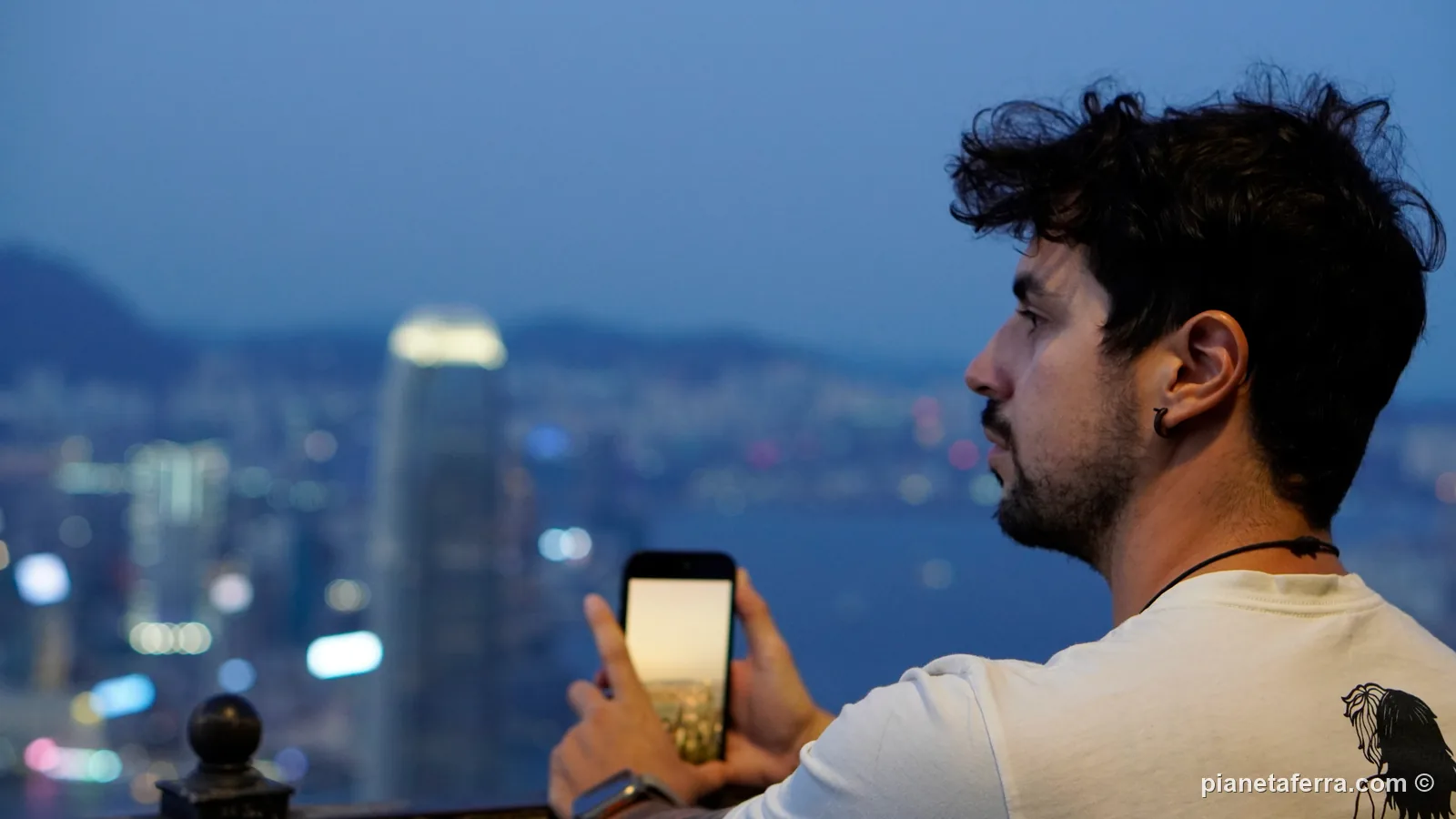 Luca al Victoria Peak di Hong Kong mentre fotografa lo skyline con il telefono