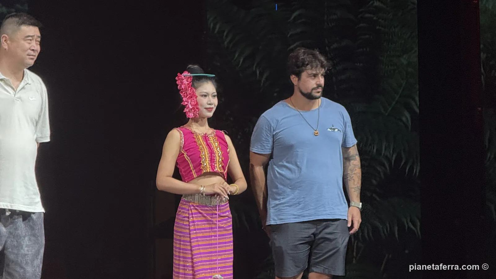 Luca invitato sul palco accanto a una danzatrice Dai durante lo spettacolo a Jinghong