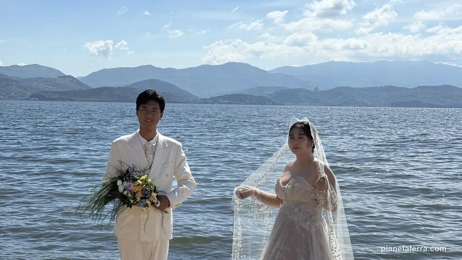 Una coppia di sposi cinesi in posa per le foto di nozze sulla riva del lago Erhai, a Dali