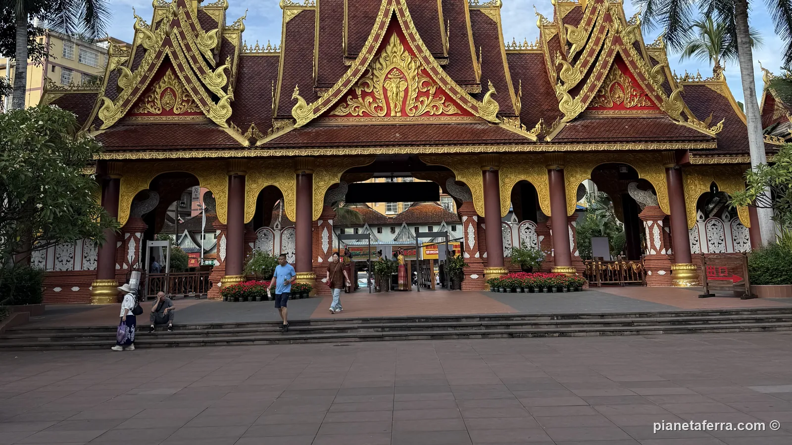 Un tempio in stile Dai a Xishuangbanna, con i tetti dorati e le palme